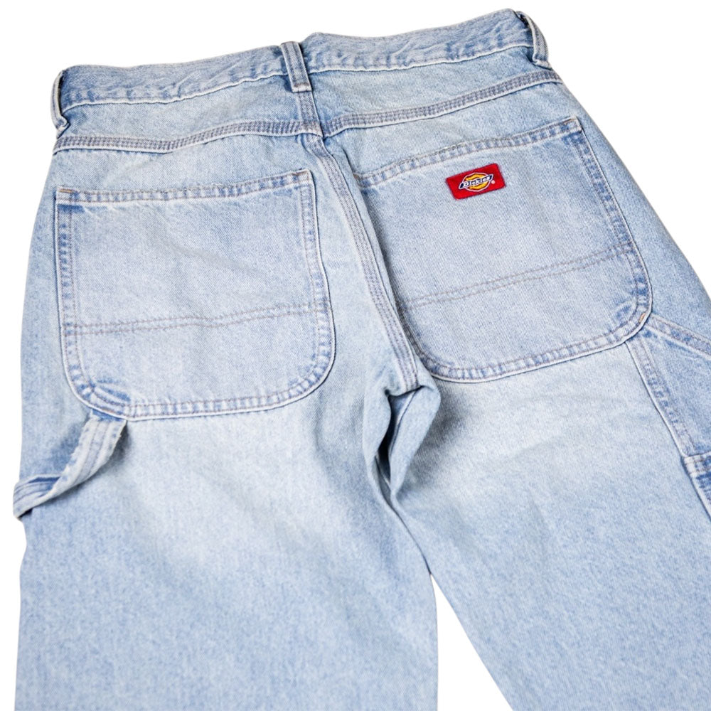 The Worn In Lightweight RI2 A89G7 Retro Indigo Men's Woven Dickies Skateboarding jeans are shown from the back, featuring two large back pockets and a red Dickies logo patch above the right pocket.
