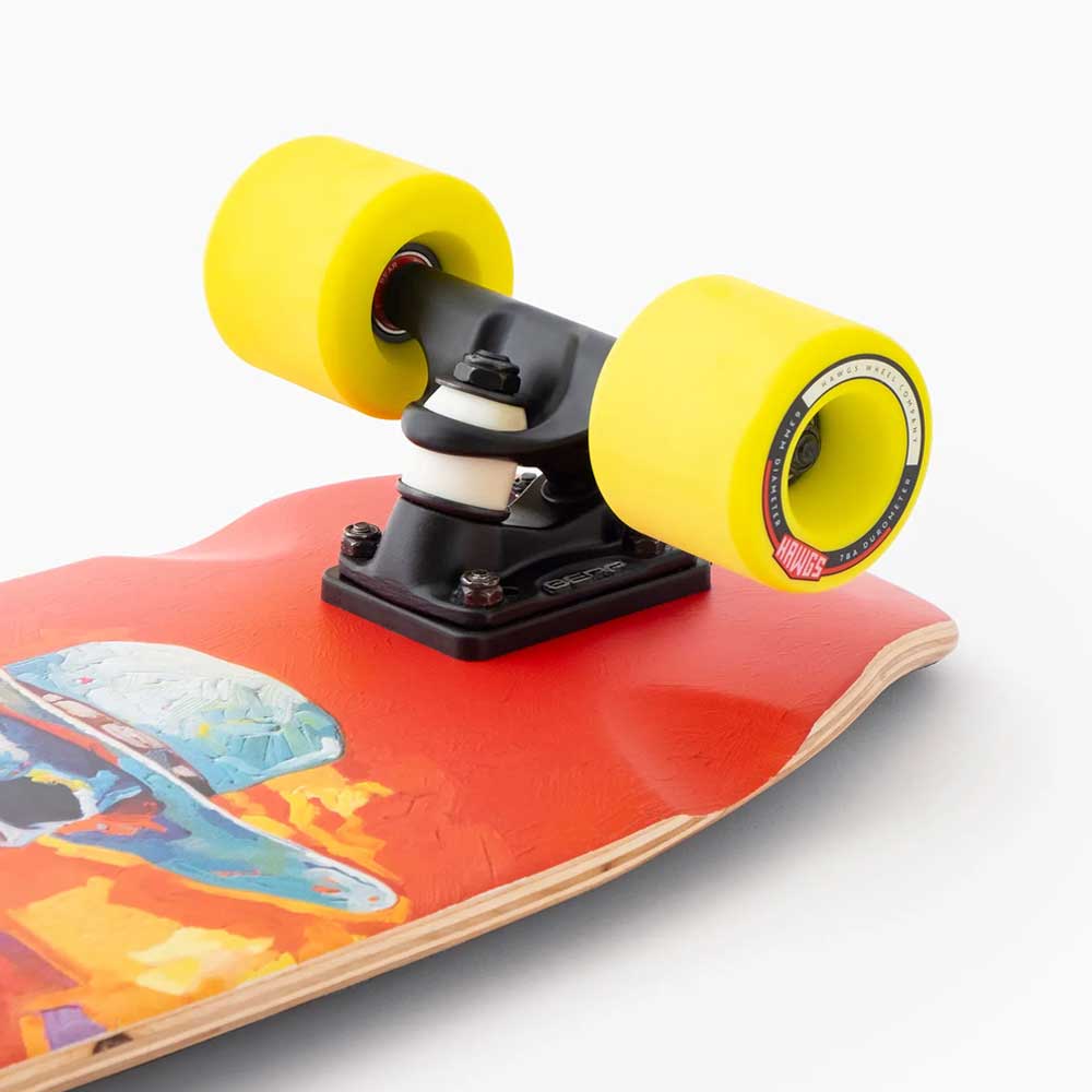 Close-up of the Dinghy Legend Classic Landyachtz Complete Skateboard’s rear truck and bright yellow wheels, showcasing colorful artwork on the red deck with molded wheel flares. The skateboard is photographed against a plain white background.