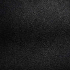 Close-up of Distressed Flat Black Relaxed Denim Jeans by Butter Goods, featuring 100% cotton fabric with a diagonal weave and textured surface, highlighted by subtle shadows.