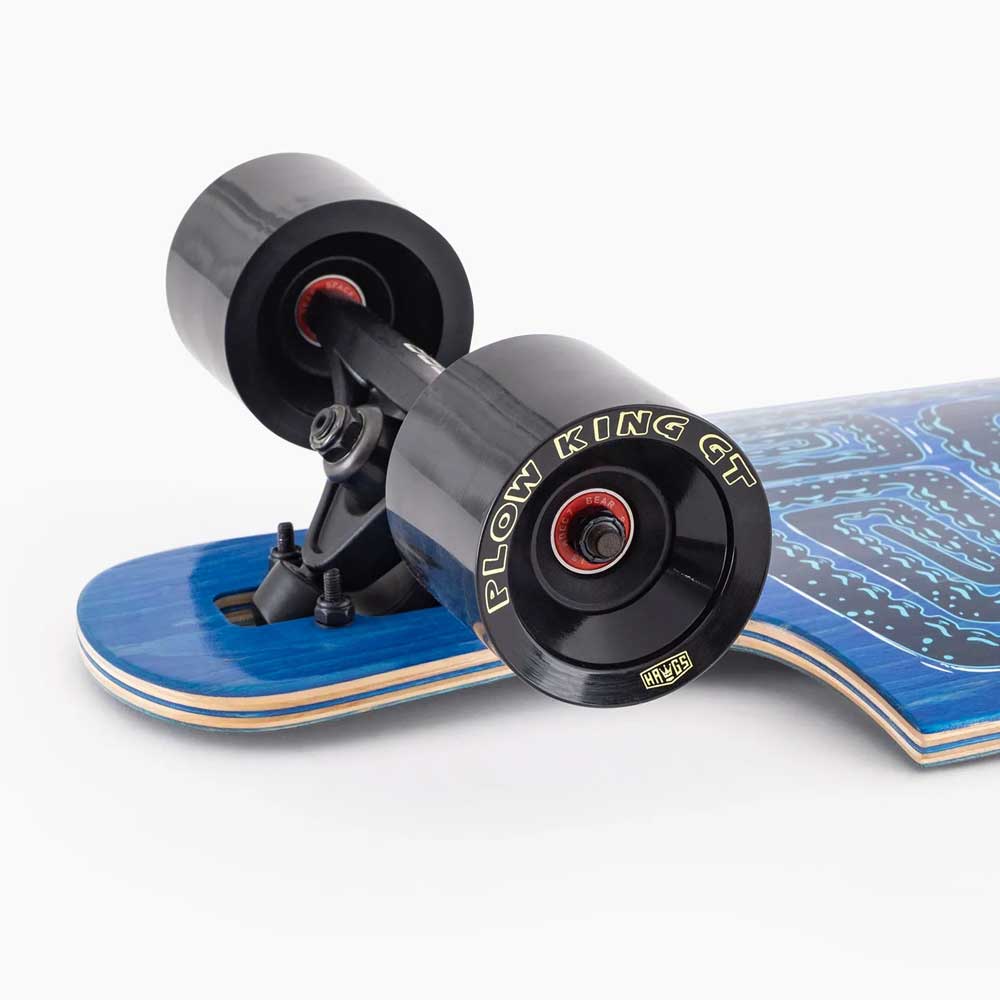 Close-up of the rear black wheels and trucks of a blue Drop Hammer Octomaze Landyachtz Complete Skateboard, with yellow PLOW KING GT text on the wheel, shown against a white background.
