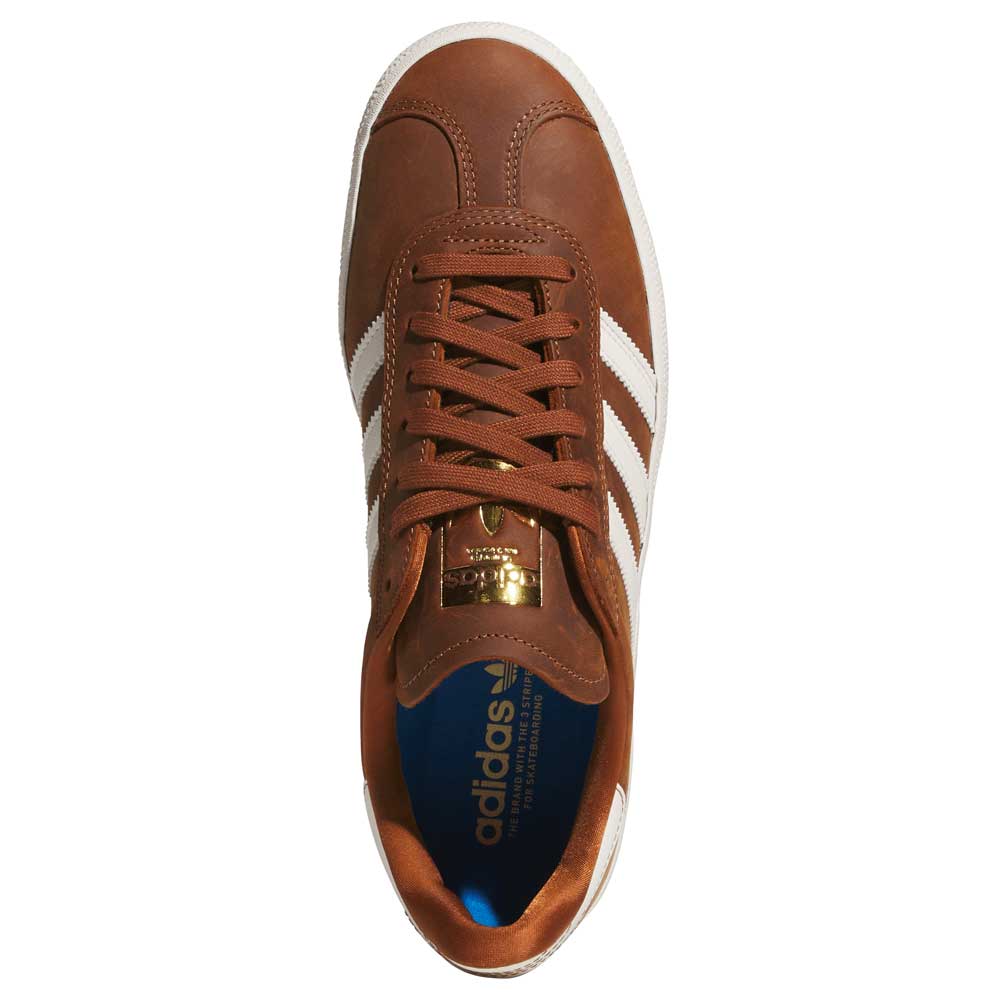 Top view of Brown White Gold Gazelle ADV HQ7547 Adidas Skateboarding Suede Shoes: brown suede with white stripes, gold branding on the tongue, brown laces, and a blue insole with the adidas logo.