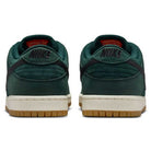 A pair of Dunk Low Pro FJ1674-300 Nike SB sneakers in Deep Fir/Black/Fir/Sail with suede uppers, black Nike logo on the heels, off-white midsoles, and gum rubber outsoles—a modern twist on classic style.