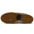 A close-up of the Nike SB Dunk Low Pro FJ1674-300 showcases its tan gum sole with unique circular and geometric tread, plus a black center section—ideal for fans of classic style. This "Deep Fir Black Fir Sail" suede sneaker blends function and heritage.