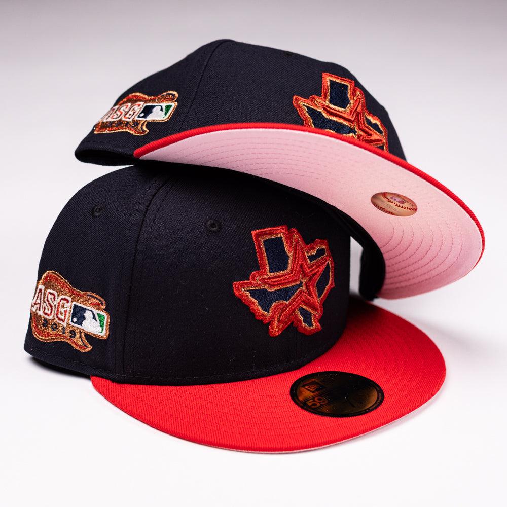 Two El Karma ASG Navy Red Houston Astros New Era Hat 5950 Fitted caps by New Era, featuring embroidered Texas state and MLB ASG logos in black and red. One cap is stacked atop the other, revealing the red underside of the brim—a must-have for dedicated Houston Astros fans.