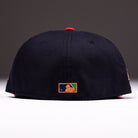 A black El Karma ASG Navy Red Houston Astros New Era Hat 5950 Fitted is viewed from the back, featuring the MLB logo embroidered in gold, green, and white on the bottom center. The background is plain and softly lit—perfect for any Astros fan seeking a stylish finishing touch.
