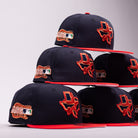 Six El Karma ASG Navy Red Houston Astros New Era Hat 5950 Fitted caps by New Era are stacked in two pyramids. Each cap showcases a navy blue crown with a red brim, decorated with a Texas state patch, “ASG” initials, and a small MLB logo on the side to celebrate the Houston Astros—all arranged against a light gray background.