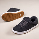 A pair of Accel Gray White Suede Es Skateboarding Shoes, featuring gray suede uppers, white soles, gum-colored outsoles with a patterned tread, dark laces, and a minimal design inspired by the classic éS Accel.
