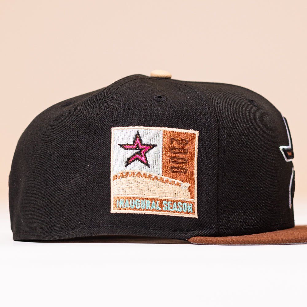 The Espresso Martini Houston Astros New Era Hat 5950 Fitted is a black and brown cap featuring a side patch with a pink star, the word “Houston,” and “Inaugural Season” text.