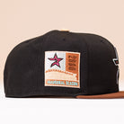 The Espresso Martini Houston Astros New Era Hat 5950 Fitted is a black and brown cap featuring a side patch with a pink star, the word “Houston,” and “Inaugural Season” text.