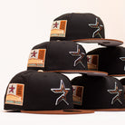Six Espresso Martini Houston Astros New Era 5950 Fitted hats are stacked, each featuring a black crown, brown brim, the signature Houston Astros star logo on the front, and a 2000 Inaugural Season patch on the side—highlighting the unique Alyyjadee design.