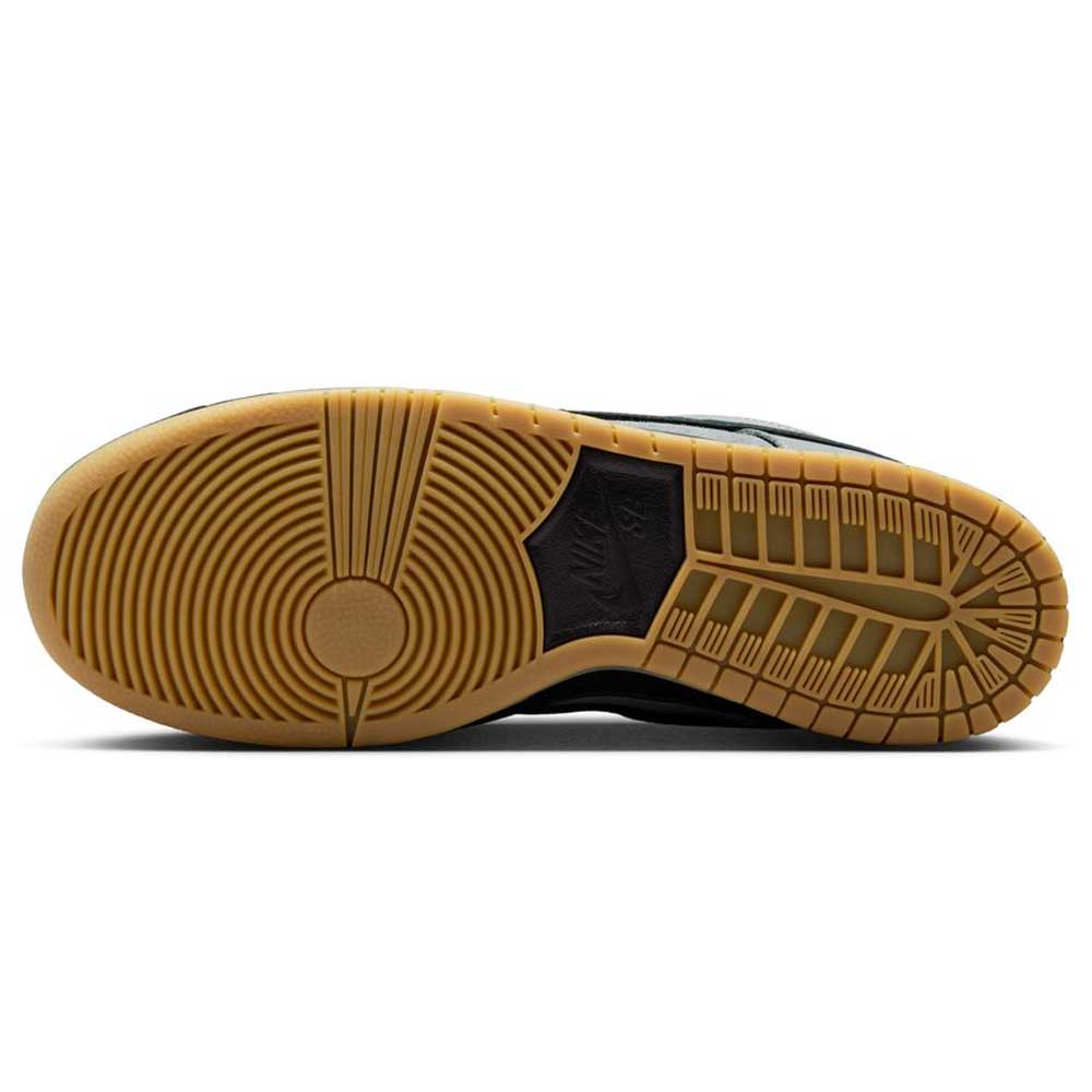 The image shows the outsole of the FJ1674002 Cool Grey Black Nike SB Dunk Low Pro Suede Shoes with a gum rubber finish. The tread has circular and linear patterns for grip, and a Nike logo appears in the center.