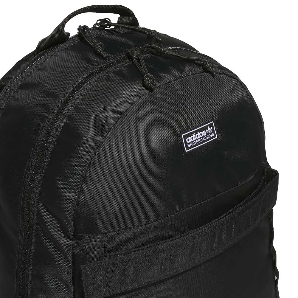 Close-up of the FSBS Backpack KS6814 Black by Adidas Skateboarding, featuring a prominent front pocket, double zippers, and a small Adidas brand label on the upper section—ideal as an everyday backpack for your essentials.