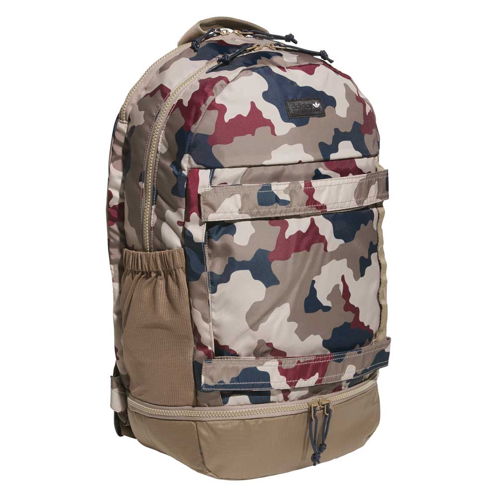 A FSBS Backpack KS6815 Khaki Camo by adidas Skateboarding featuring a camouflage pattern in tan, brown, blue, and burgundy hues, equipped with multiple zippered compartments, a front pocket, and a side mesh pocket.