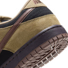 Close-up of the heel and outsole of the Filbert Light Chocolate Black Burgundy Ash Dunk Low Pro HQ1625201 Nike SB Skateboarding Shoe, featuring tan suede, black accents, a brown stripe, and a detailed tread pattern on the sole.