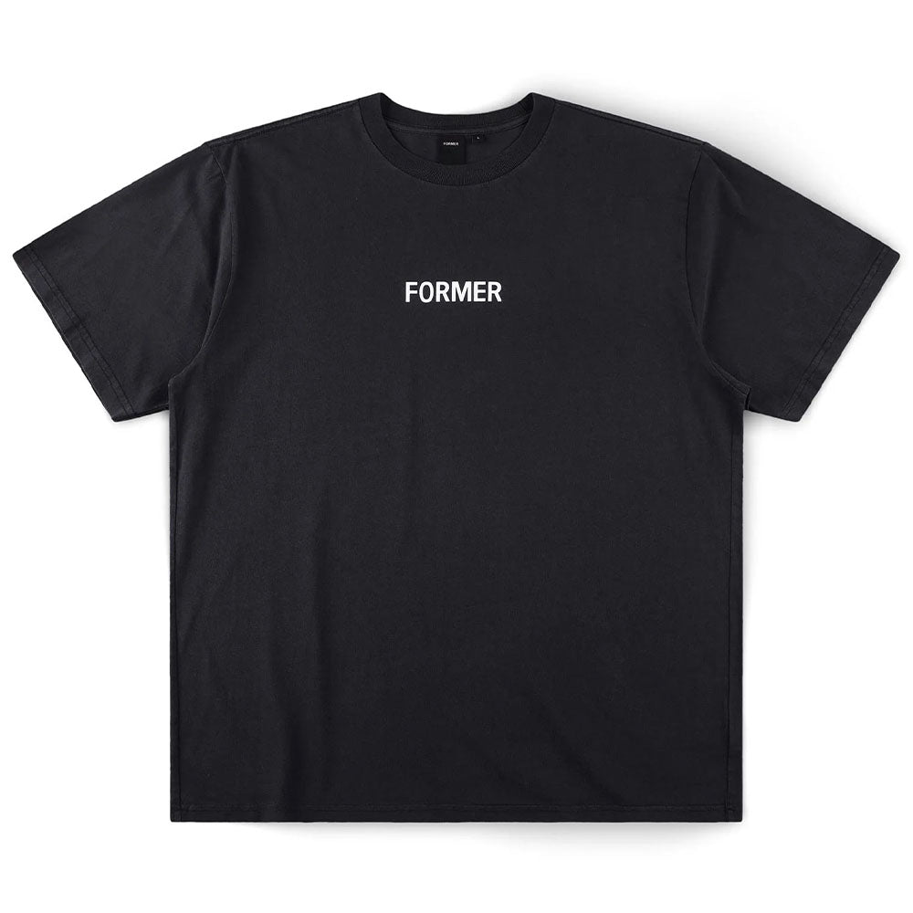 The Legacy Overdye Former Tee in Washed Black is a plain black 200GSM cotton T-shirt featuring the word FORMER screen printed in bold white uppercase letters at the center of the chest. The shirt has a subtle vintage finish and is displayed laid flat on a white background.