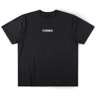 The Legacy Overdye Former Tee in Washed Black is a plain black 200GSM cotton T-shirt featuring the word FORMER screen printed in bold white uppercase letters at the center of the chest. The shirt has a subtle vintage finish and is displayed laid flat on a white background.
