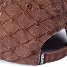 Close-up of the Alleviate Cap Former Hat Bark, featuring a brown textured fabric with a diamond pattern, crafted from durable 200GSM cotton, and finished with a black FORMER tag near the adjustable strap.