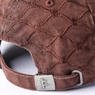 Here’s a rewritten sentence using the provided product data: Close-up of the back of the Alleviate Cap Former Hat Bark, showcasing its textured brown 200GSM cotton construction with a geometric stitched pattern, metal clasp, embossed F logo, and an adjustable fabric strap.