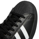 Close-up of the GW6931 Black White Superstar ADV Adidas Skateboarding leather shoe featuring white stripes, black laces, and a textured rubber toe cap—ideal for skateboarding.