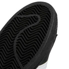 Close-up of the black rubber outsole on GW6931 Black White Superstar ADV Adidas Skateboarding Leather Shoes, showing a zigzag tread and circular grooves, plus part of the black and white upper—the ideal skateboarding footwear style.