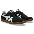 A pair of Gel Vikka Pro Asics Black Brown 1201A486 suede skateboarding shoes with white stripes and brown rubber soles, designed for superior board control and enhanced comfort with GEL cushioning, is shown at a slight angle on a plain white background.
