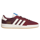A Glenburn Burgundy White KJ5048 Adidas skateboarding shoe with a maroon upper, classic white stripes, a white heel, gold branding accents, and a white sole featuring a gum bottom is shown from the side on a plain background—ideal for anyone seeking timeless skateboarding shoe style and comfort.