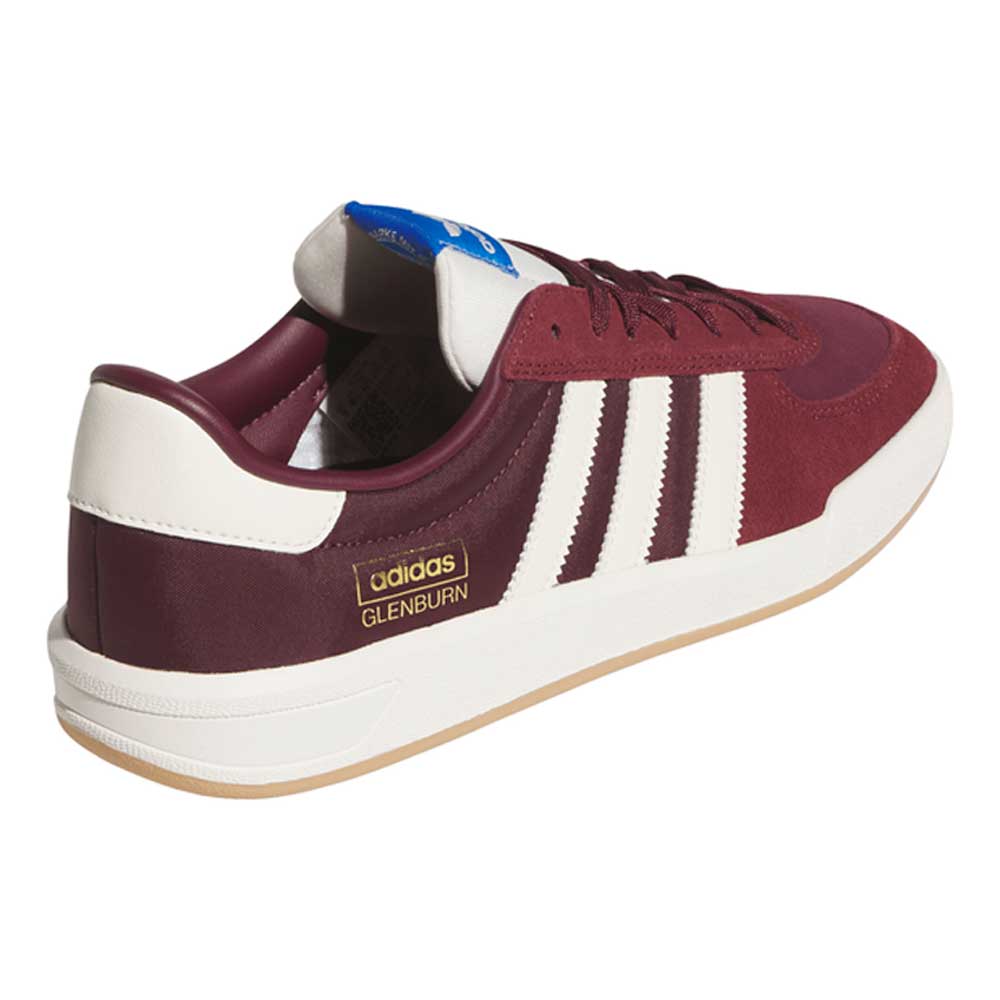The Glenburn Burgundy White KJ5048 Adidas Skateboarding Shoes feature a maroon upper with signature white stripes, a white sole, white heel tab, and a gold GLENBURN label on the side. A blue Adidas logo tag decorates the tongue—these shoes offer a stylish tribute to classic skateboarding footwear.