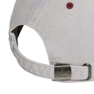 Close-up of the Gonz Cap Gray Burgundy KS6800 by Adidas, an adjustable light gray hat featuring a metal clasp with engraved logo, fabric strap, and a maroon stitched eyelet on the back.