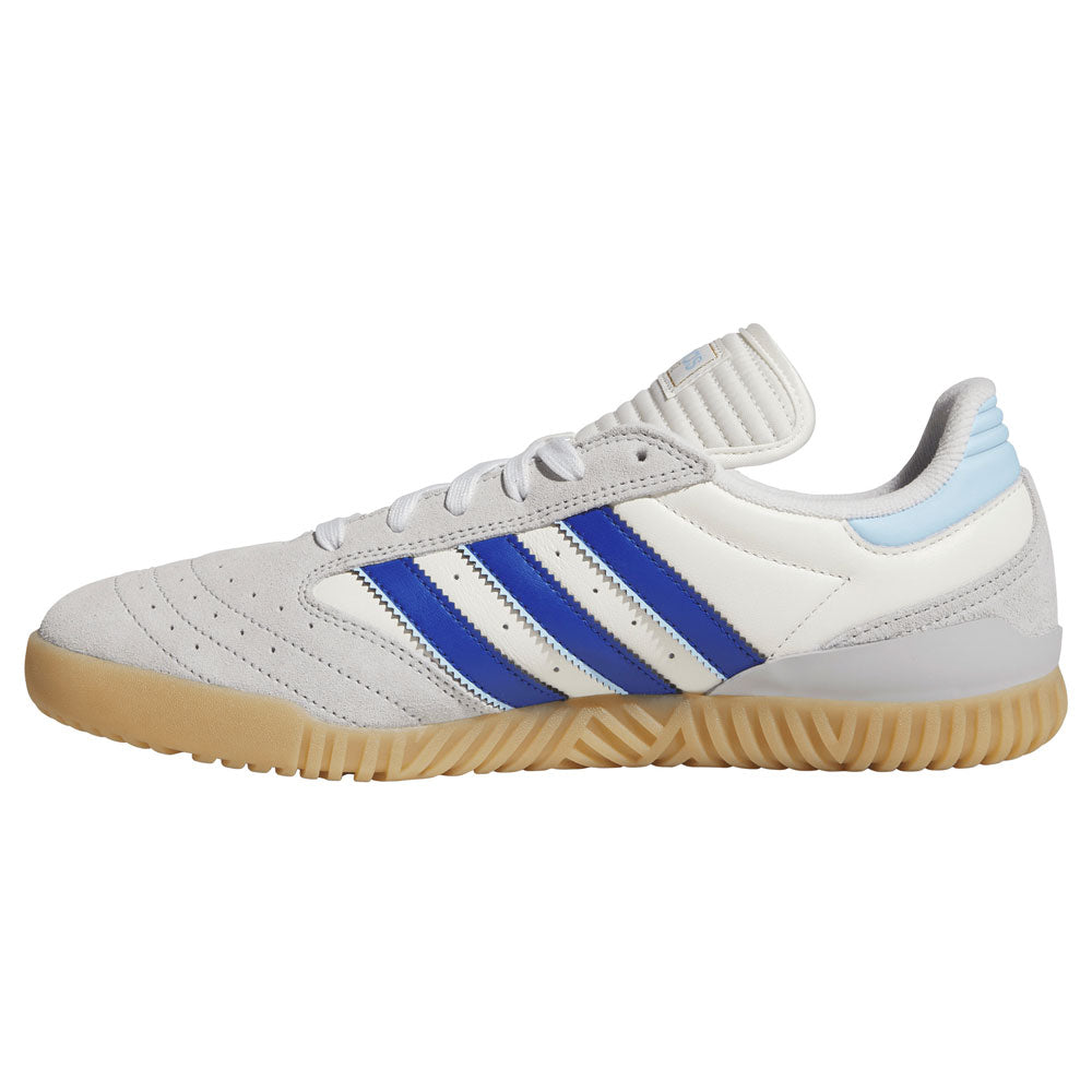 A white and gray adidas suede skateboarding shoe featuring royal blue stripes on the side, light blue accents on the heel, white laces, and a tan rubber sole—embodying the iconic style of the Gray Royal Blue KZ8895 Busenitz Indoor Adidas Skateboarding Shoes.