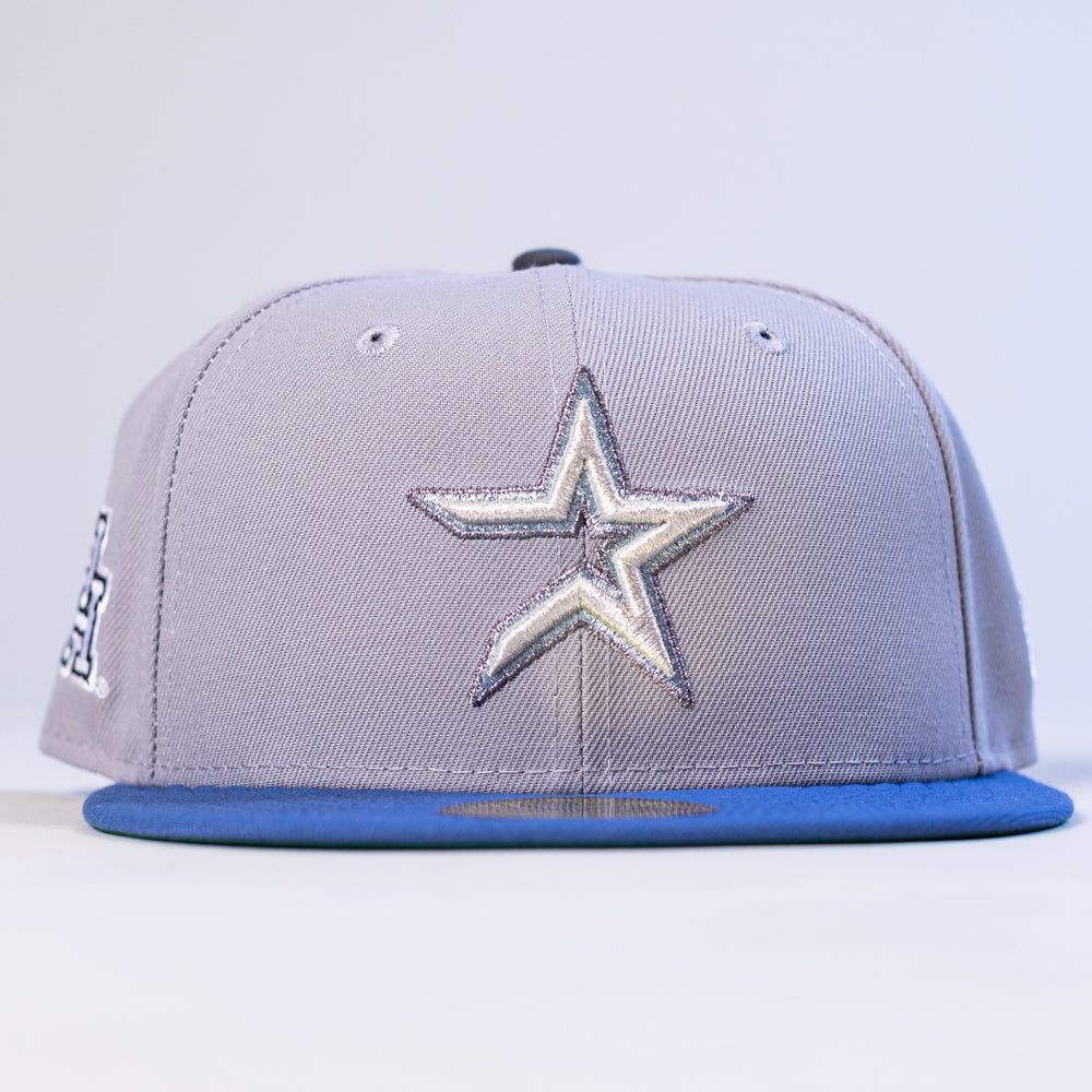 The Peoples Champ Gray Blue Houston Cougars New Era Hat 5950 Fitted features a silver and white star emblem on the front, a striking blue visor, and is showcased against a plain background—making it an ideal choice for Houston Cougars fans looking to stand out.
