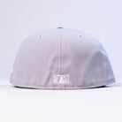 A light gray and blue Peoples Champ Houston Cougars New Era Hat 5950 Fitted is displayed from the back, highlighting a small white rectangular logo at the center bottom and ventilation eyelets on top. This fitted cap provides both comfort and classic Houston Cougars style.