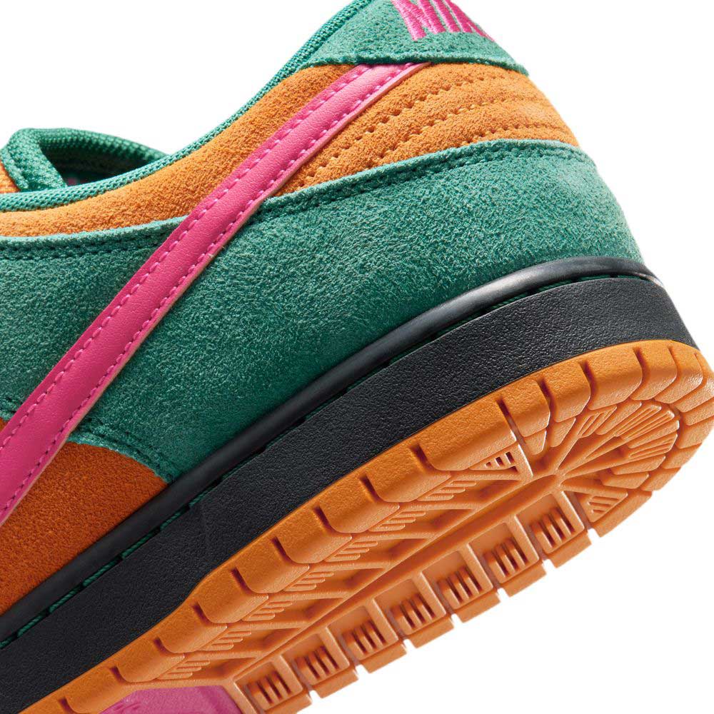 Close-up of the heel and sole of the Nike SB Dunk Low Pro "Green Noise Watermelon Light Curry" (HQ1625301), featuring green, orange, and pink suede panels, leather upper, pink stripe, and an orange rubber outsole with black midsole accents.