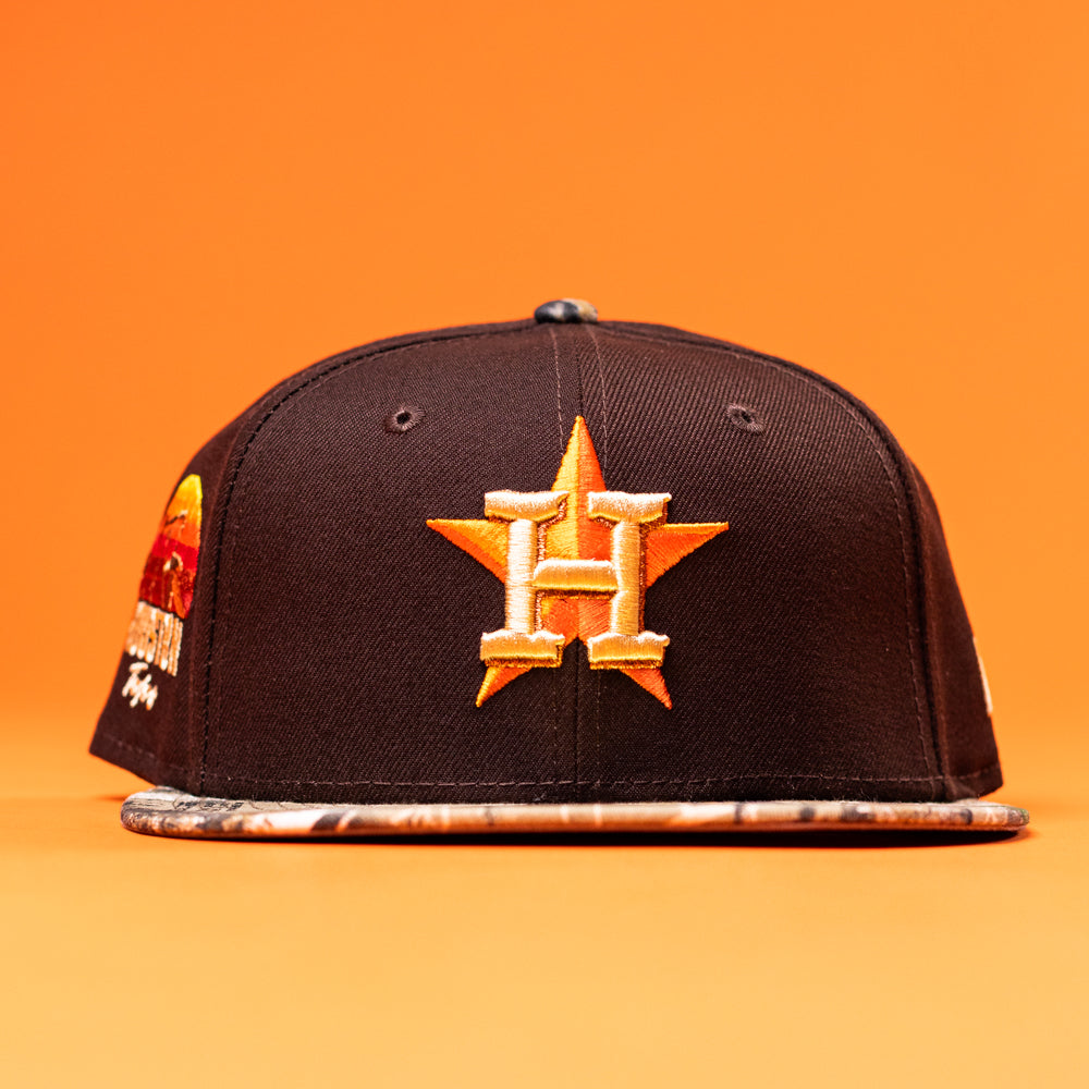 The Old Head RTC Wood Oil Houston Astros New Era 5950 Fitted Hat features a gold star and orange H logo, a patterned brim, and a colorful side patch, shown against an orange background.