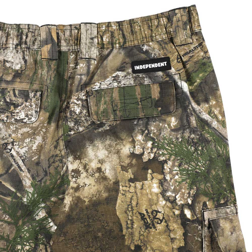 Close-up of the Groundwork 2 Cargo Pants Realtree APX Bottom Mens Independent in green, brown, and tan camouflage—REALTREE colorway—showing a back pocket with a black INDEPENDENT label above it; part of the Independent Trucks apparel collection.