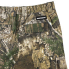 Close-up of the Groundwork 2 Cargo Pants Realtree APX Bottom Mens Independent in green, brown, and tan camouflage—REALTREE colorway—showing a back pocket with a black INDEPENDENT label above it; part of the Independent Trucks apparel collection.