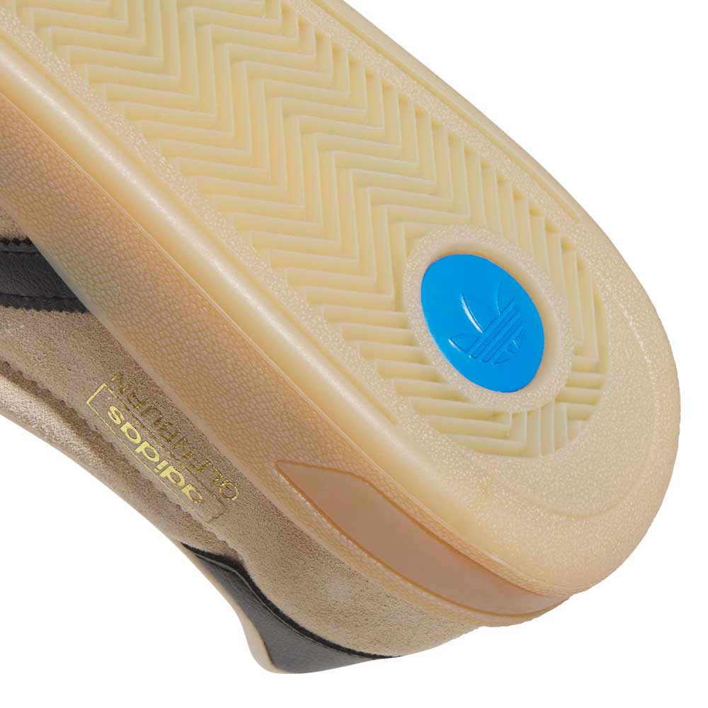 Close-up of the beige sole on HP3510 Tan Black Glenburn Adidas Skateboarding Suede Shoes, showcasing a herringbone tread, blue circular logo, and gold adidas branding—great for skateboarding and streetwear fans.