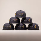 Six dark grey Black Delta City Connect Houston Astros New Era Hat 5950 Fitted caps stacked in a pyramid, each featuring a yellow and red star logo with the word STROS embroidered on the front.