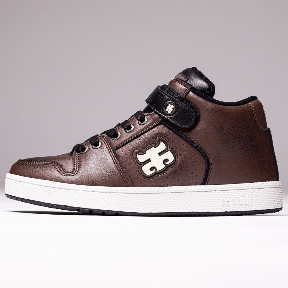 The Grasshopper Brown Leather I Path Shoes Skateboarding features a high-top brown leather design with black laces, black trim, and a white logo on the side. This shoe includes a comfortable Ortholite insole, a white sole, and is accented with a strap near the top bearing a small emblem.