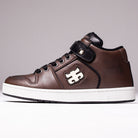 The Grasshopper Brown Leather I Path Shoes Skateboarding features a high-top brown leather design with black laces, black trim, and a white logo on the side. This shoe includes a comfortable Ortholite insole, a white sole, and is accented with a strap near the top bearing a small emblem.