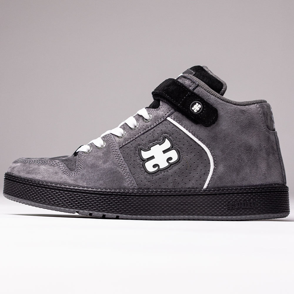 The Grasshopper Gray Suede I Path Shoes Skateboarding features a grey suede upper in a high-top design, complemented by white laces, a black sole, and a black strap. The side showcases the distinctive white and black IPATH Grasshopper logo, along with small perforations near the arch for added detail.