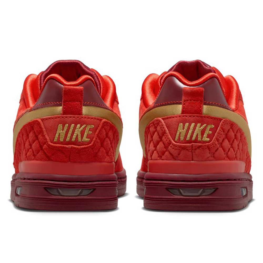 Rear view of Nike SB Paul Rodriguez Zoom Air Low skate shoes (IQ5648600) in Habanero Red and Club Gold, featuring a suede upper with quilted details, gold “NIKE” heel text, and maroon outsoles for traction, set on a white background.