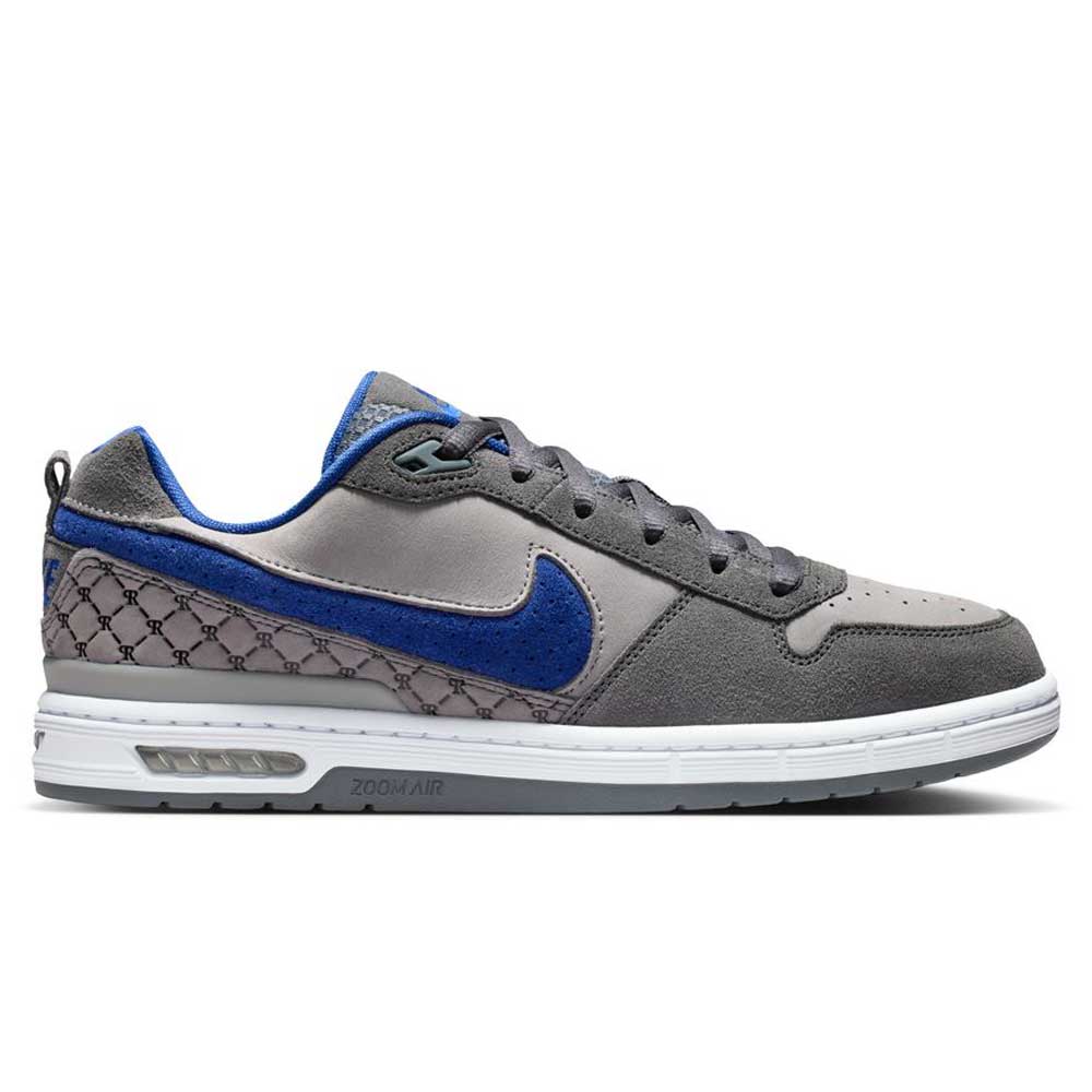 The IU7835001 Flint Grey Deep Royal Blue Paul Rodriguez Zoom Air Low Suede Skateboarding Shoes feature a grey suede upper, blue swoosh and accents, black patterned heel, durable traction, grey laces, and a white sole with visible Zoom Air cushioning.