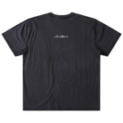 The Illusion Former Tee Washed Black is laid flat, featuring short sleeves and a premium cotton construction. Small white cursive text is screen printed and centered near the upper back, with no other visible designs.