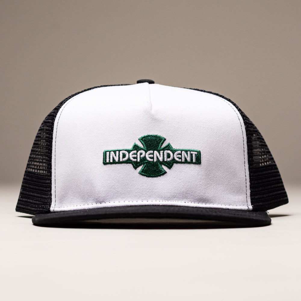 The OGBC Legacy White/Dark Green Shadow Snapback Hat from Independent Skateboards is a black and white unstructured cotton twill hat with "Independent" embroidered in green on the front, perfect for skateboard fans.
