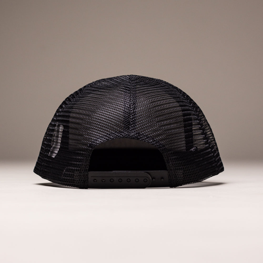 The OGBC Legacy Black Orange Shadow Snapback Hat from Independent Skateboards features a black unstructured design with an adjustable closure and mesh material that lets light filter through.