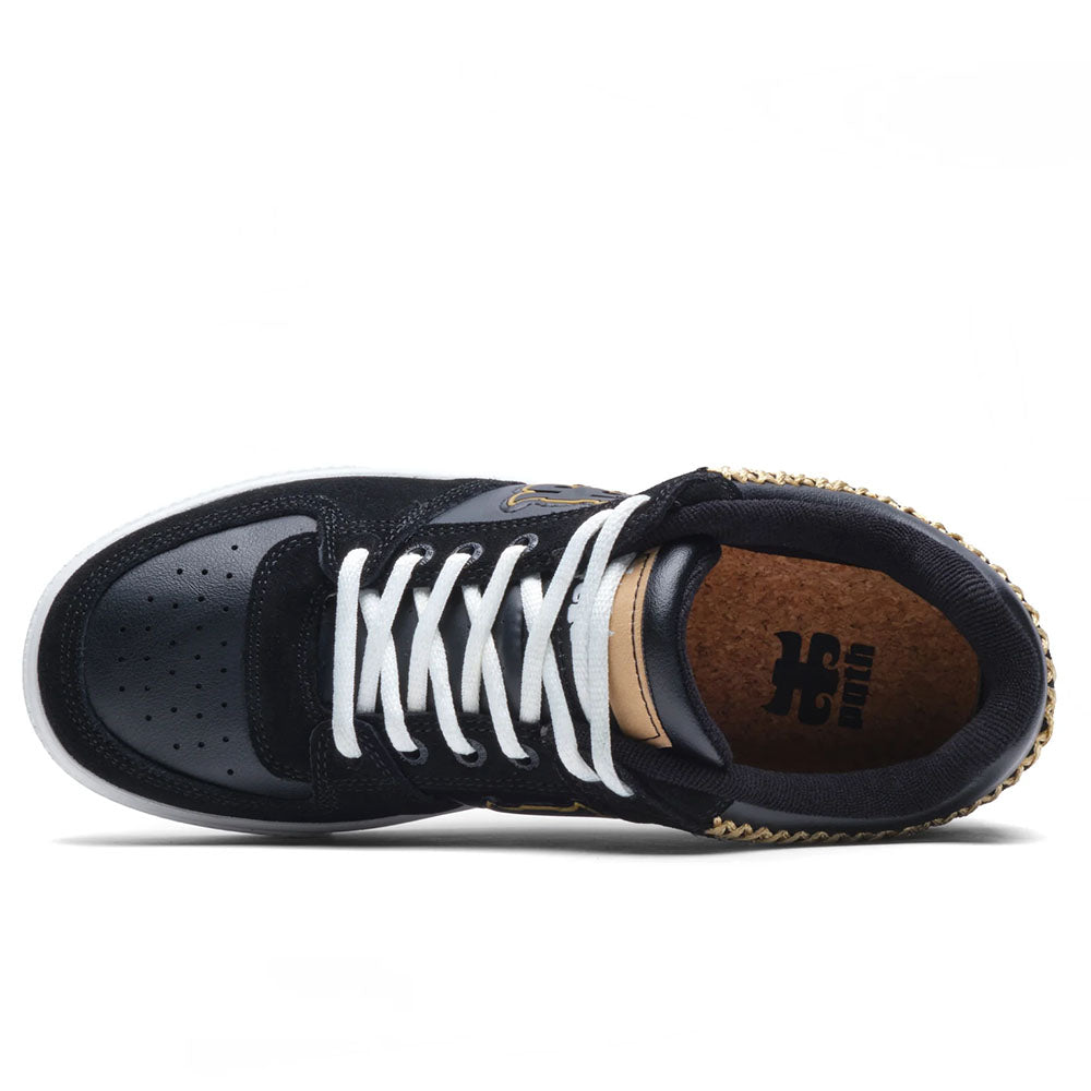 The Kenny Reed Low Vulc Black Leather Suede I Path Skateboarding shoe by Puma is shown from above, with white laces, a perforated toe, black and gold colors, and a brown insole featuring the Puma logo.