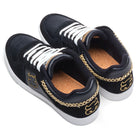 The Kenny Reed Low Vulc Black Leather Suede I Path Shoes feature black leather, white soles and laces, gold embroidery on the heels and sides, gold chain detail at the back, and brown cork inner soles—blending style and skateboarding function.