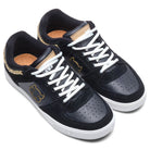 The Kenny Reed Low Vulc Black Leather Suede I Path Shoes feature white soles and laces, gold accents, a gold chain on the heel, and a stylized bear logo—perfect statement skate shoes inspired by the iconic style.