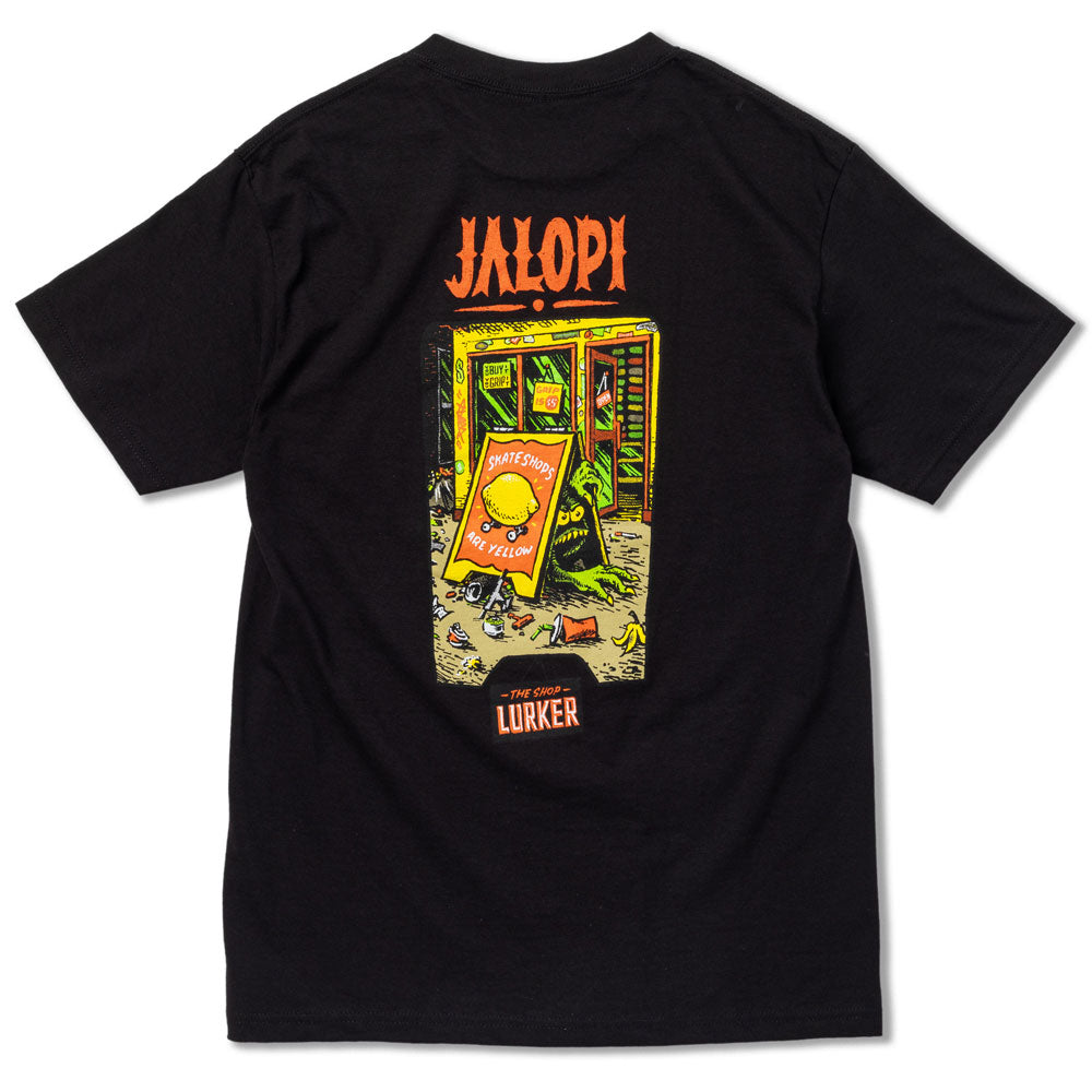 The Jalopi Shop Lurker Black Tee by Anti Hero Skateboards features a colorful phone booth cartoon with a yellow character holding a “Smartshop of Lurker” sign and “JALOPI” and “LURKER” printed above and below—perfect for skaters.