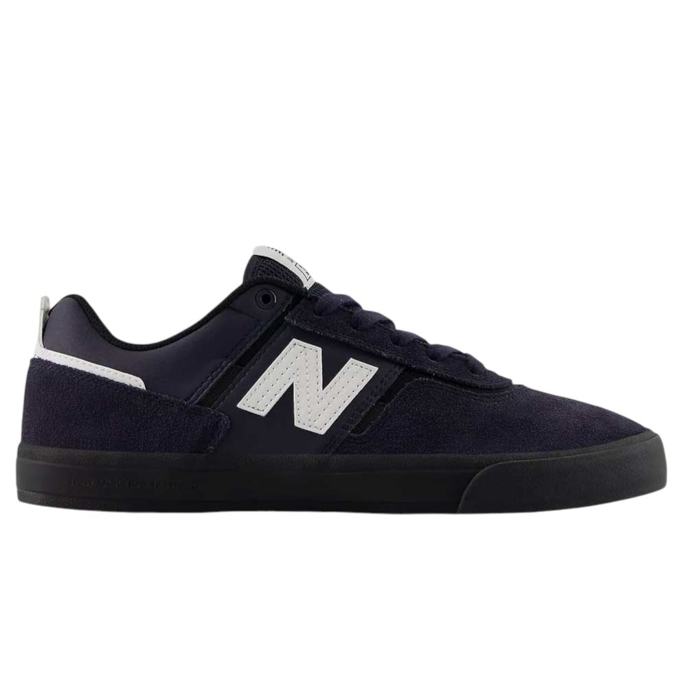 The Jamie Foy Eclipse White 306 NSN New Balance Numeric Suede Skateboarding Shoe features a sleek navy blue suede upper with a white N logo on the side, complemented by black laces and a black sole. Shown in side profile on a white background, this stylish vulcanized skate shoe draws inspiration from the Jamie Foy pro model.